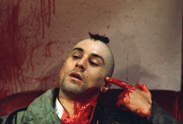 1976 --- Robert De Niro as Travis Bickle points a bloody finger at his head in a suicidal gesture on the set of Martin Scorsese's Taxi Driver. --- Image by © Steve Schapiro/Corbis